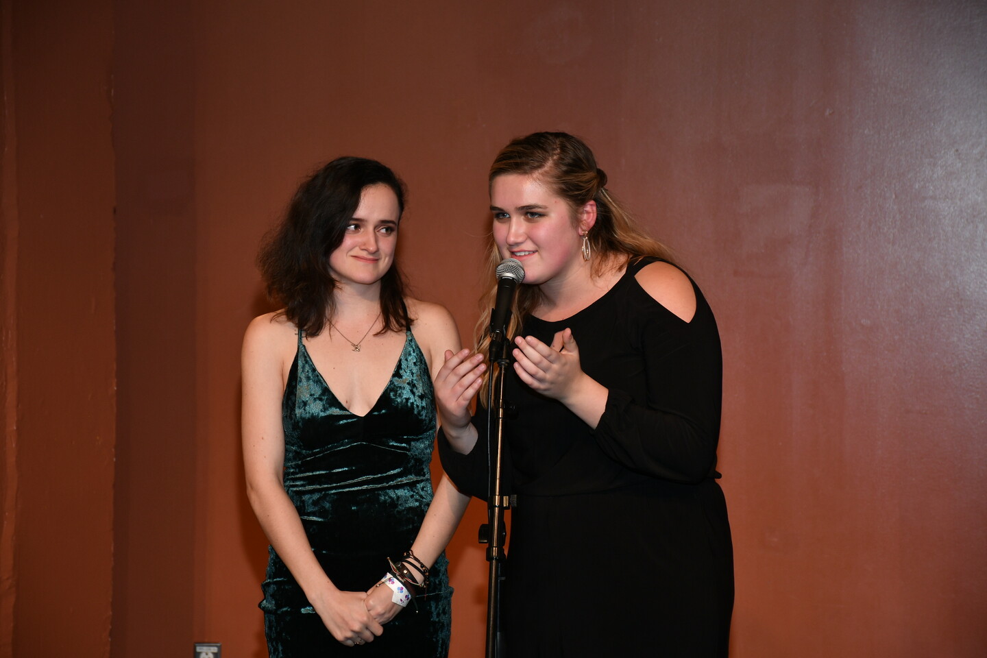Priscilla Felten speaks into the microphone while Tessa Goodine, the chair of Stimulus Theater, looks on