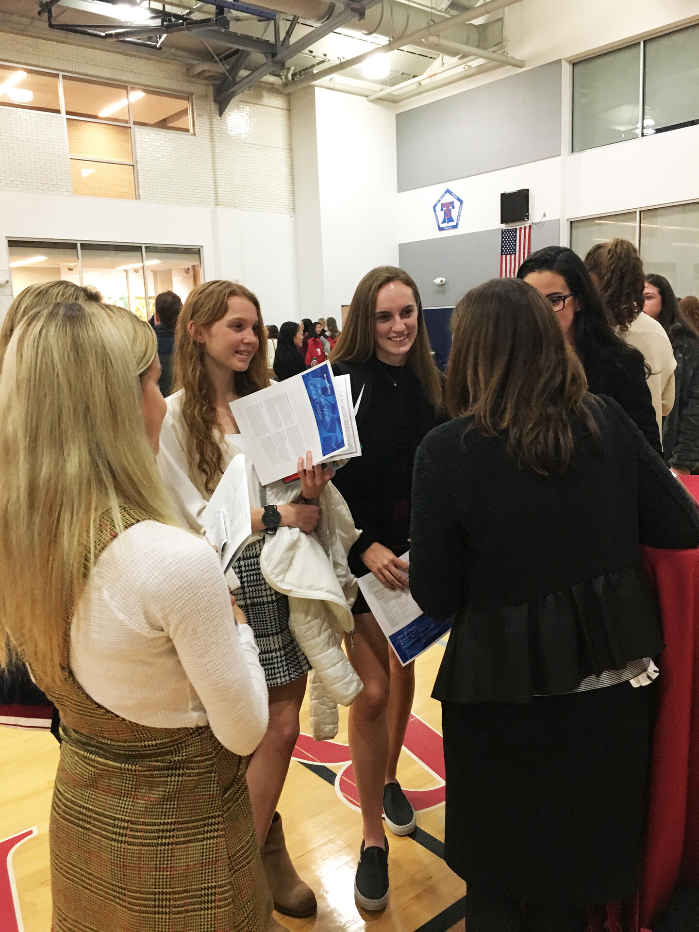 Students gather around and listen to a speaker