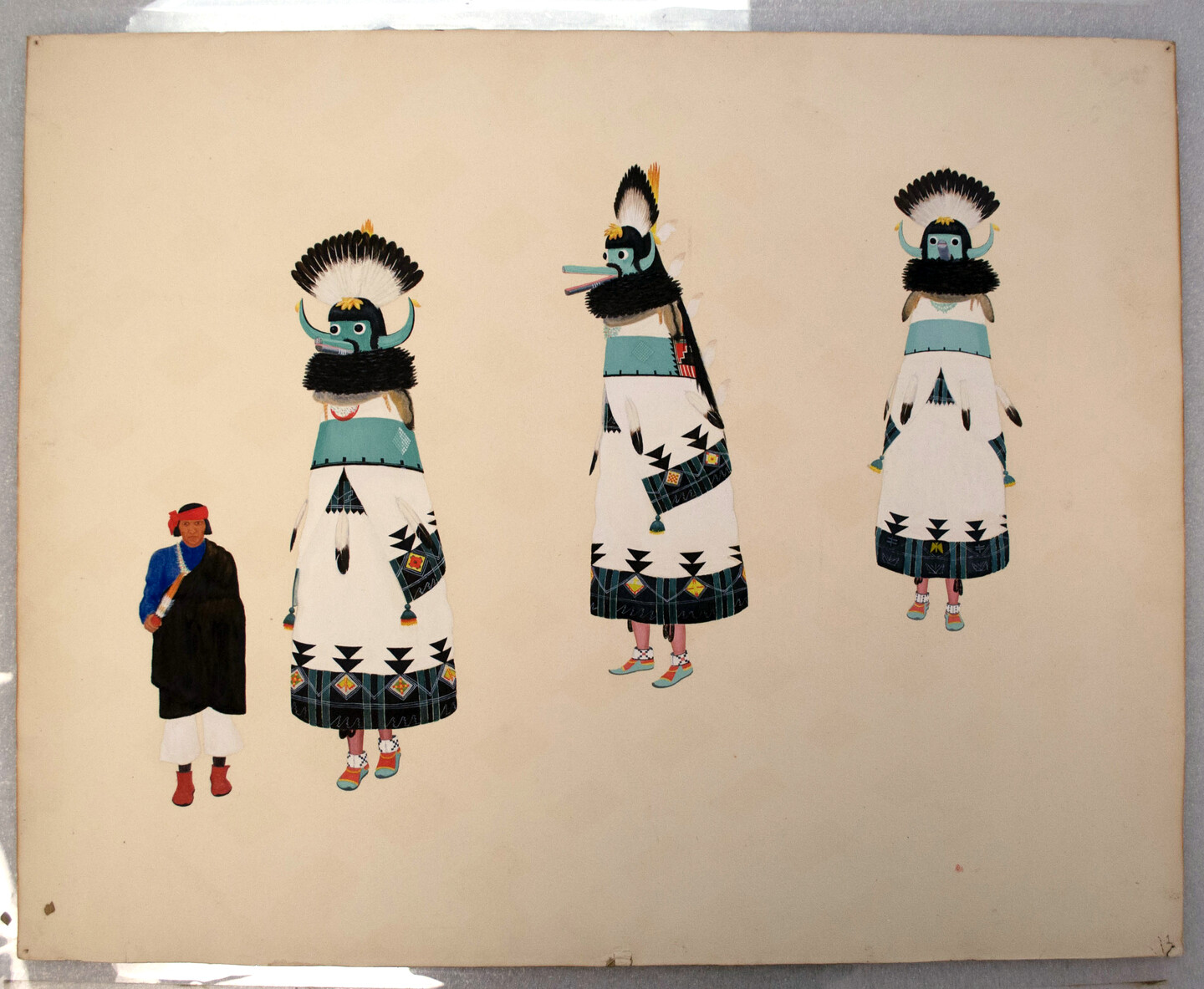 Native American man standing next to three figures dressed in white garments with bird-like headdresses