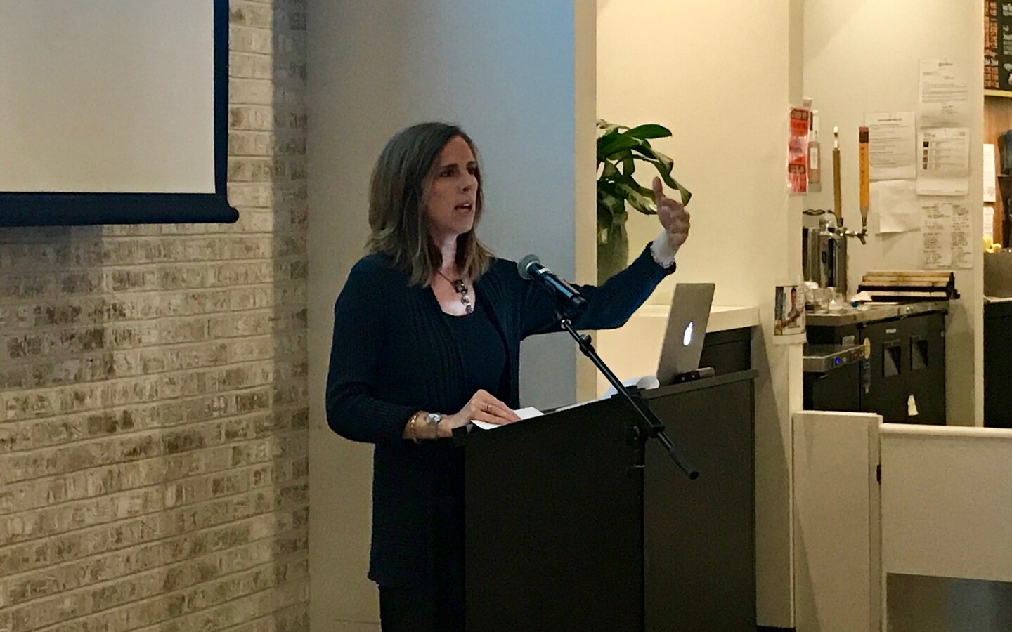 Meta Mazaj speaking at podium.