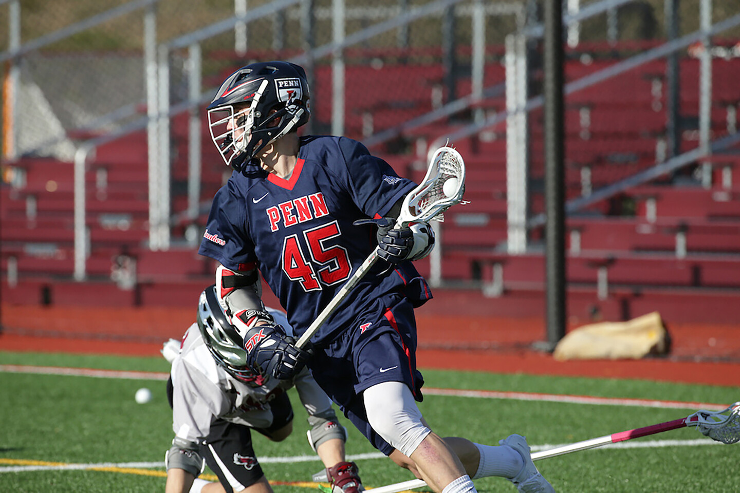 Simon Mathias of the lacrosse team prepares to shoot the ball.
