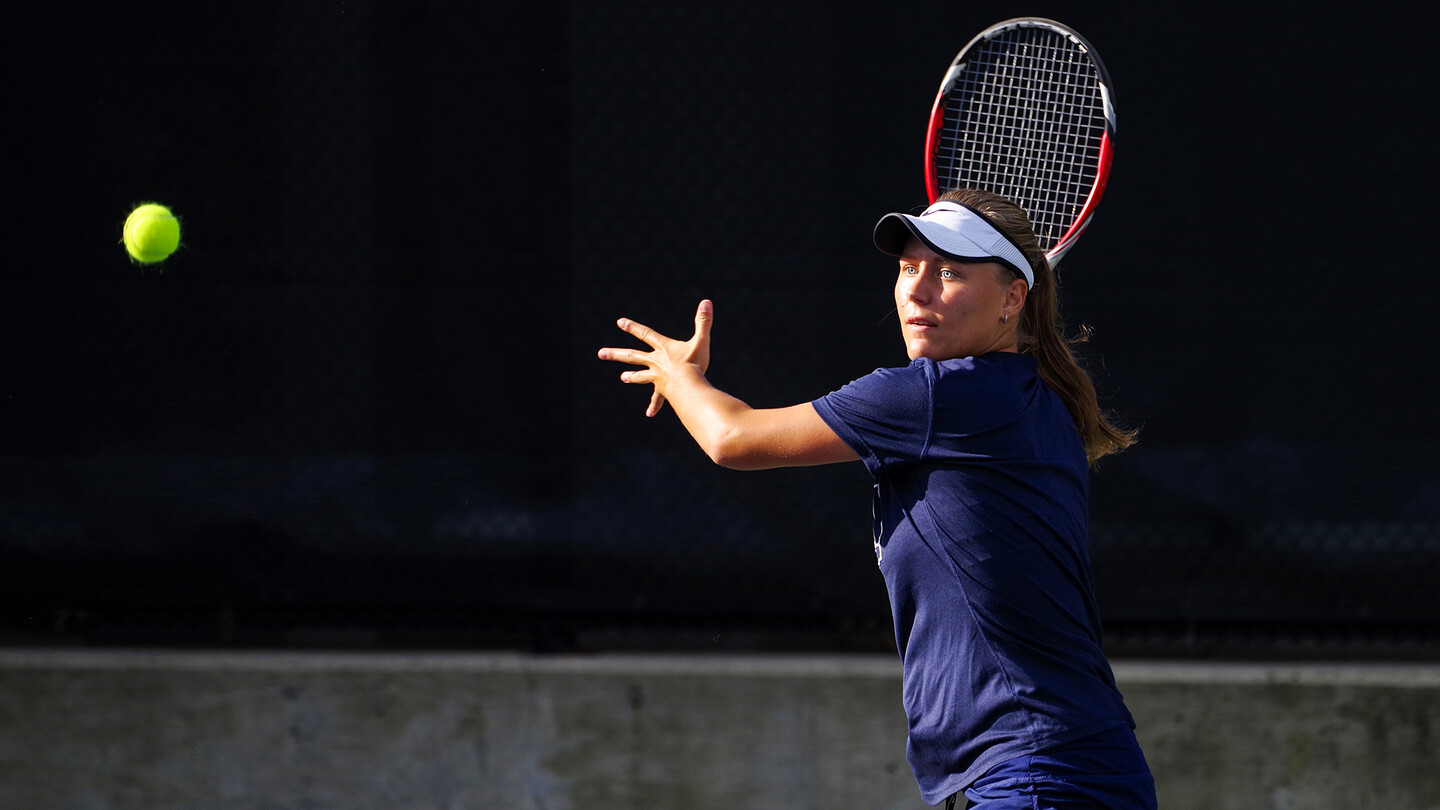 Iuliia Bryzgalova prepares to return a serve as the ball approaches her.