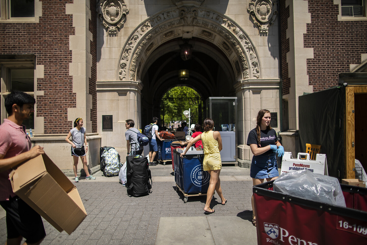 Students outside pushing moving carts and holding boxes during Move-Out day.