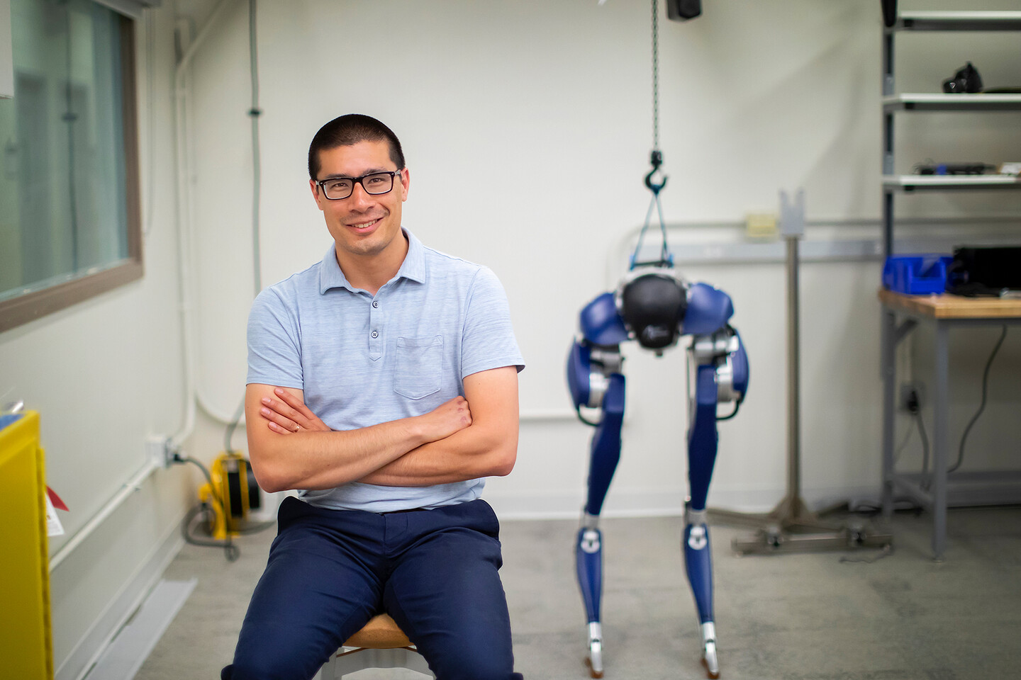 posa posing in a workshop lab with the CASSIE legs in the background
