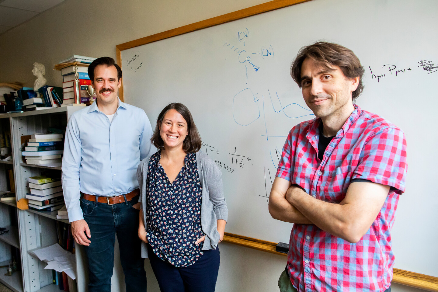 schelter, anna, and subotnik pose in front of a white board with chemical reactions written on it