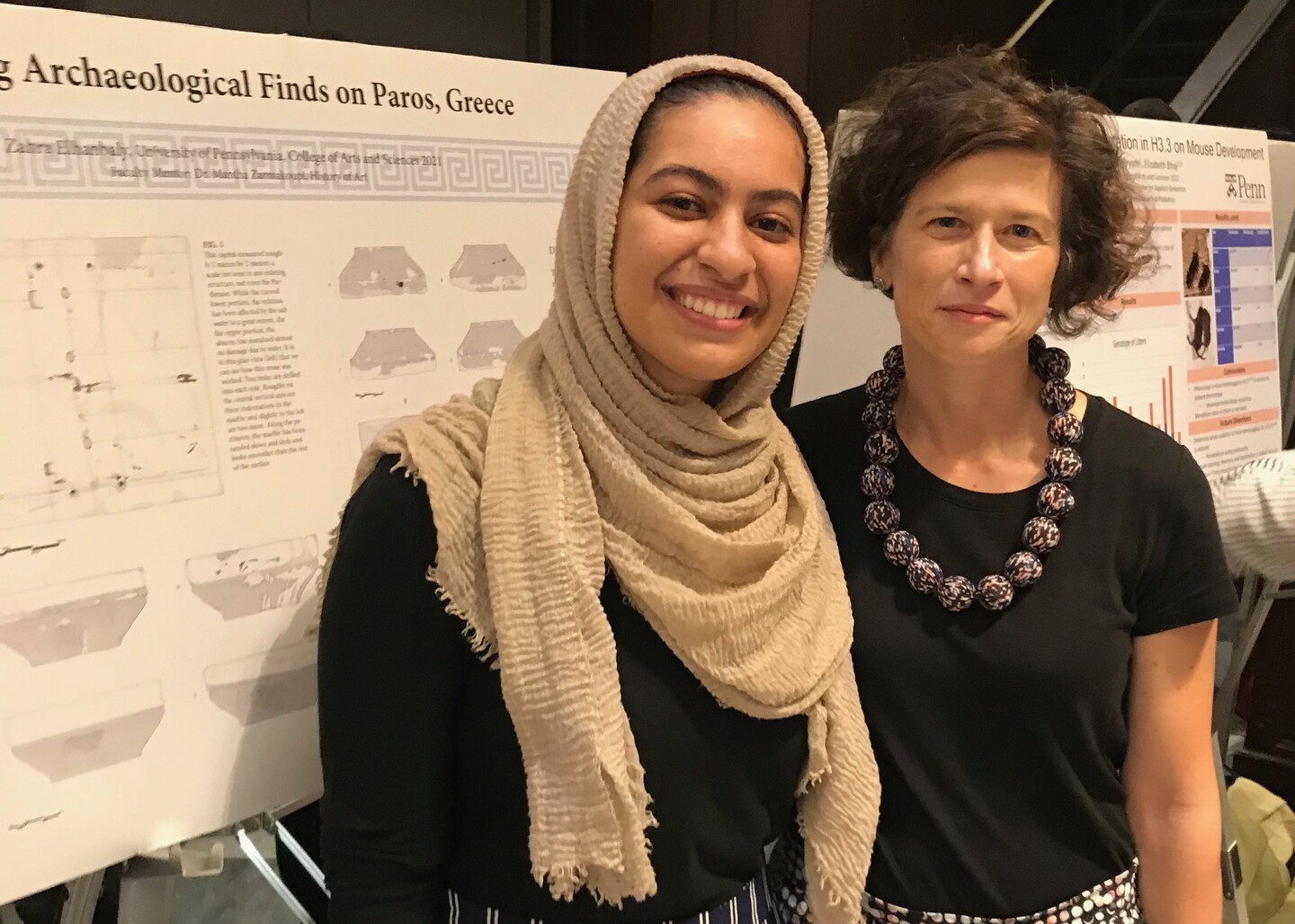 Two people standing in front of a research poster. 