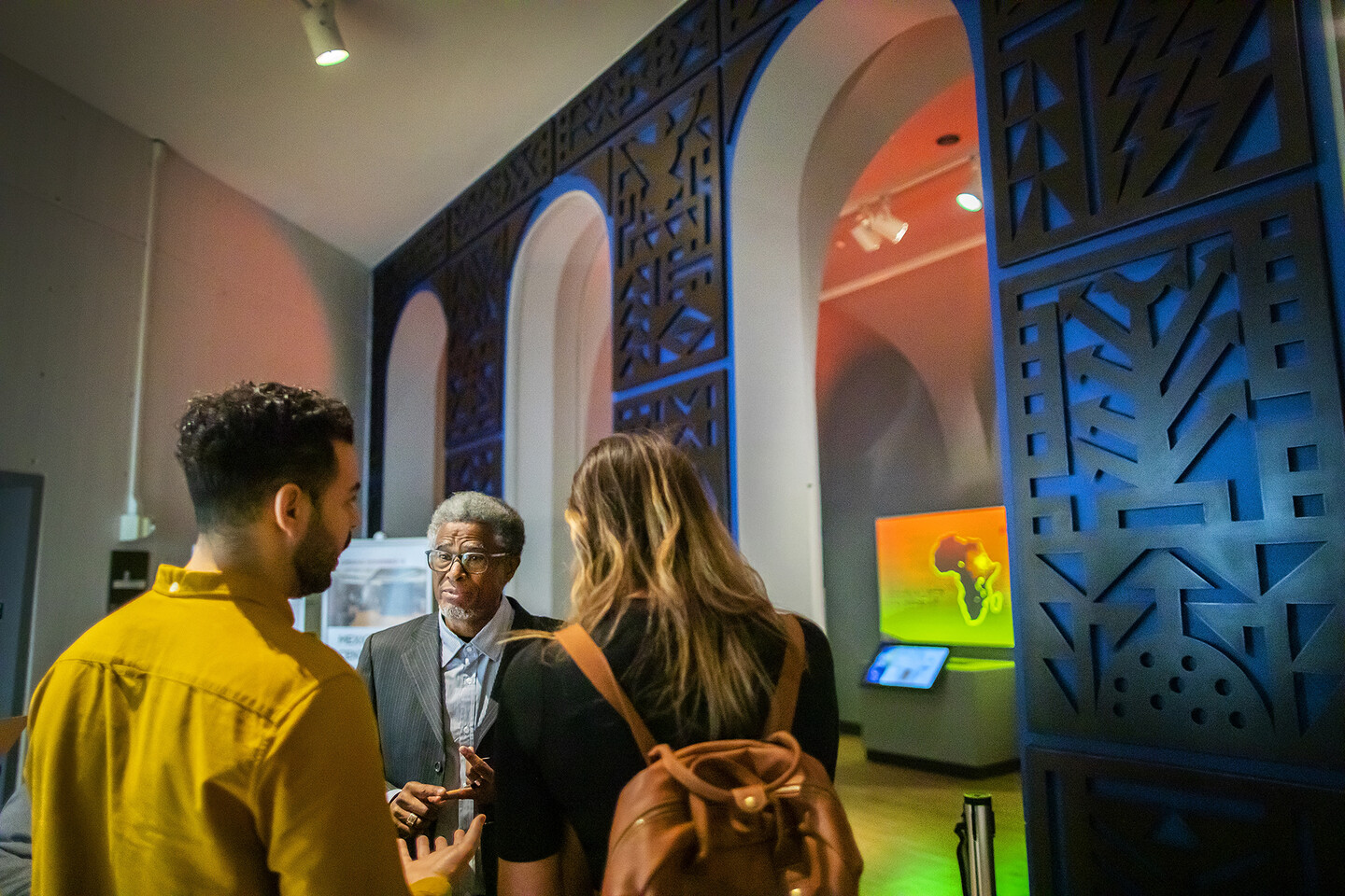 Three people talking in a museum entrance