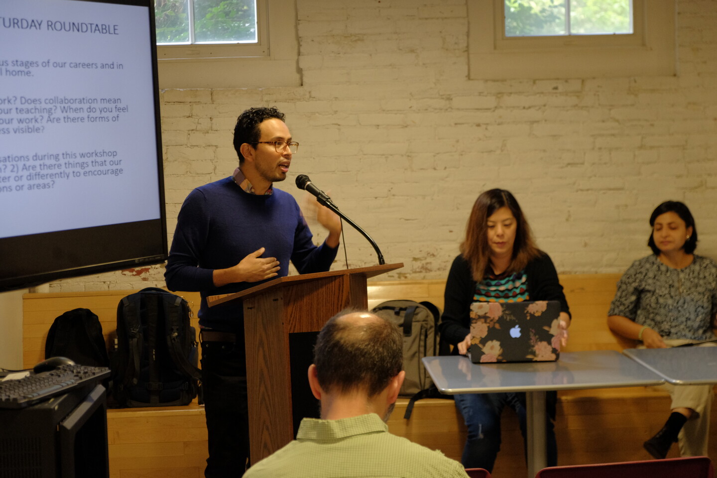 Man with glasses speaks at a podium 