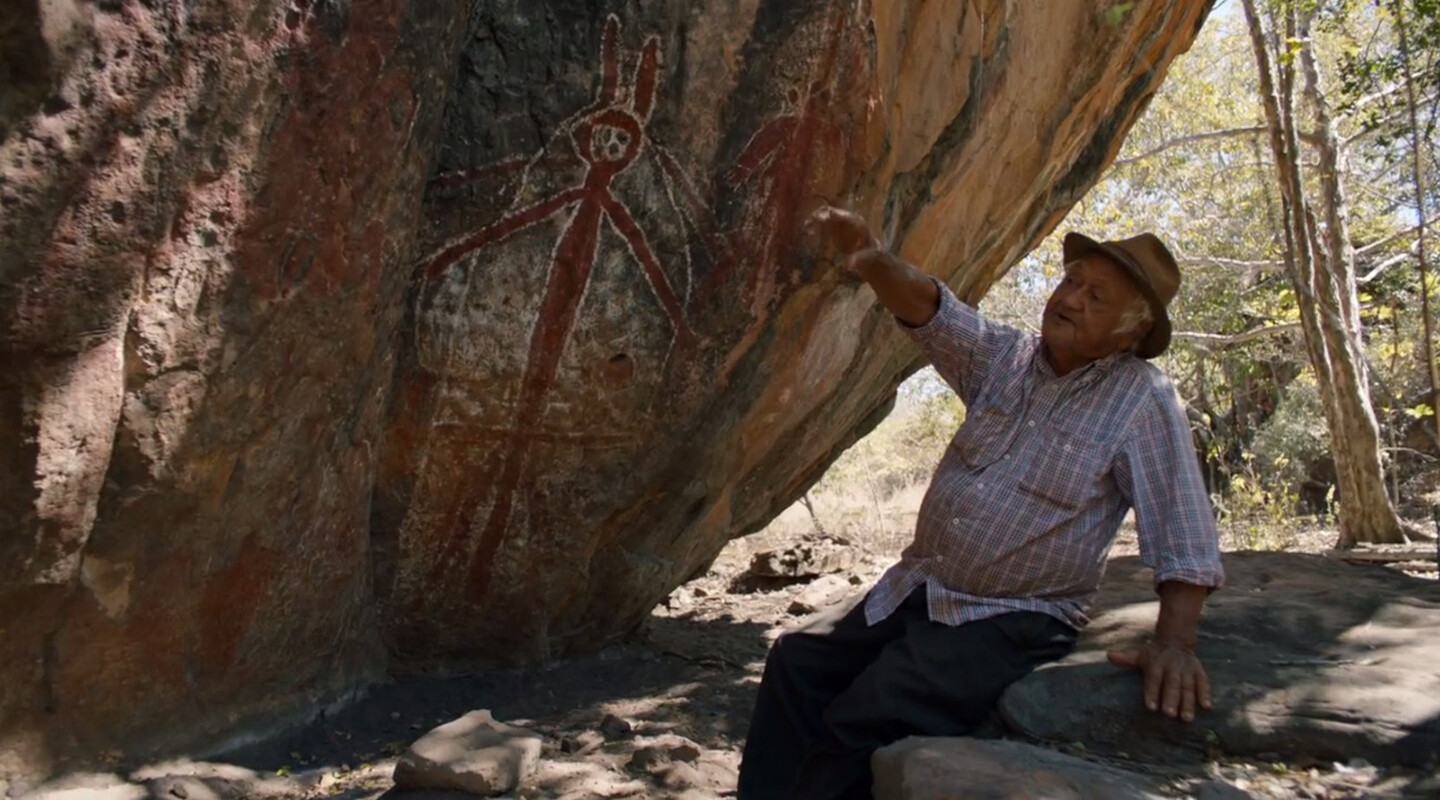 Person points to paintings on a rock