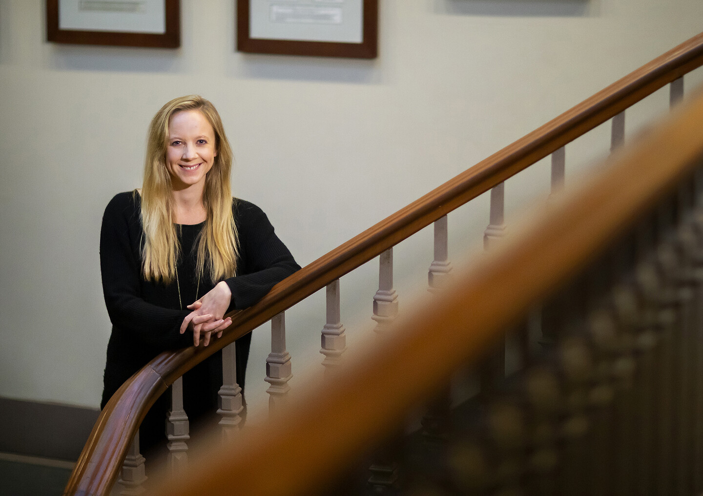 Smiling person poses along stairs