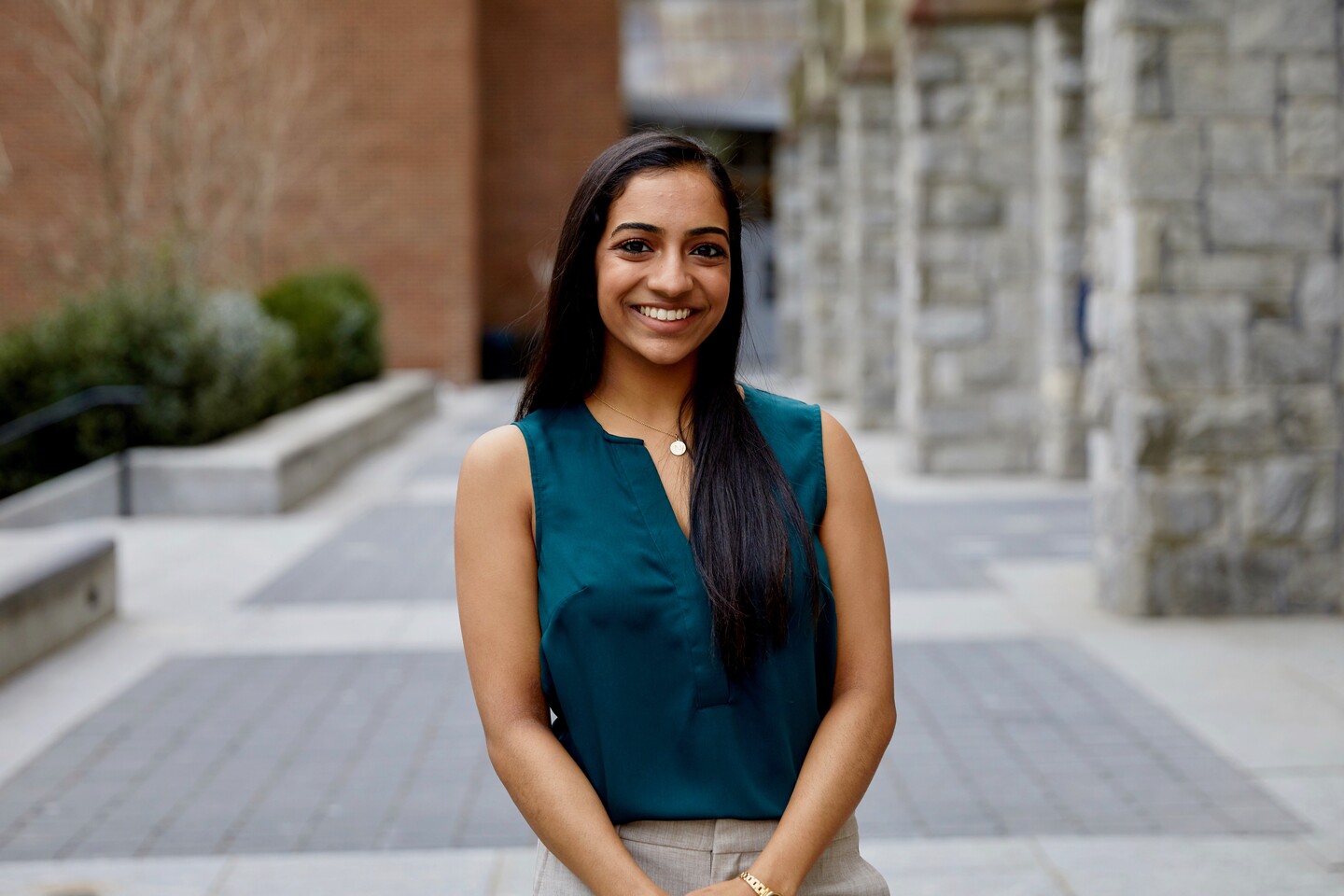 Student standing outside a stone building. 