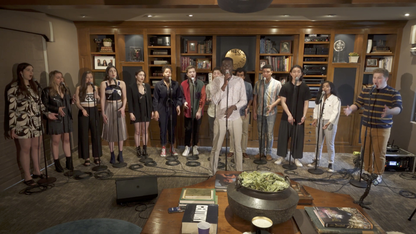 Fourteen students singing at microphones together. 