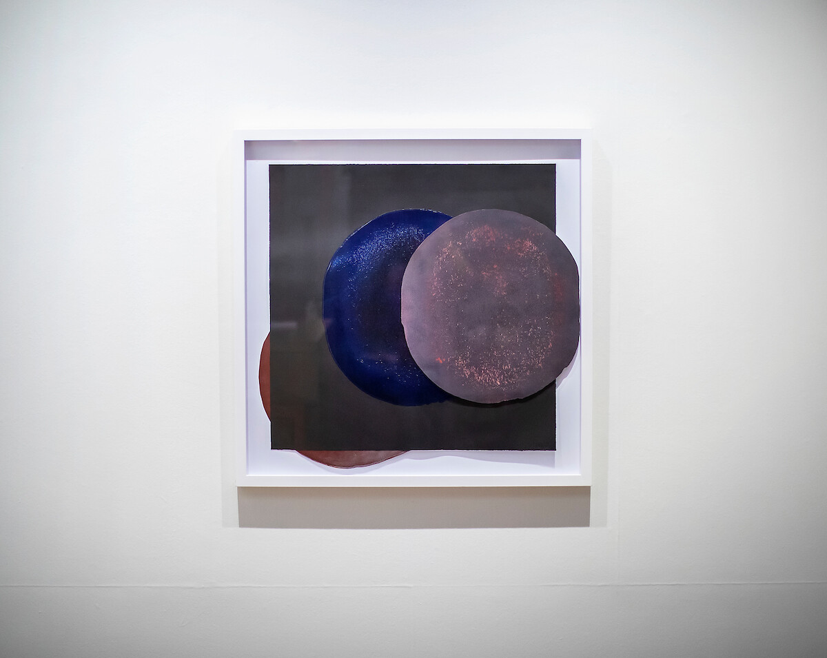 Artwork with three circles on a square. 