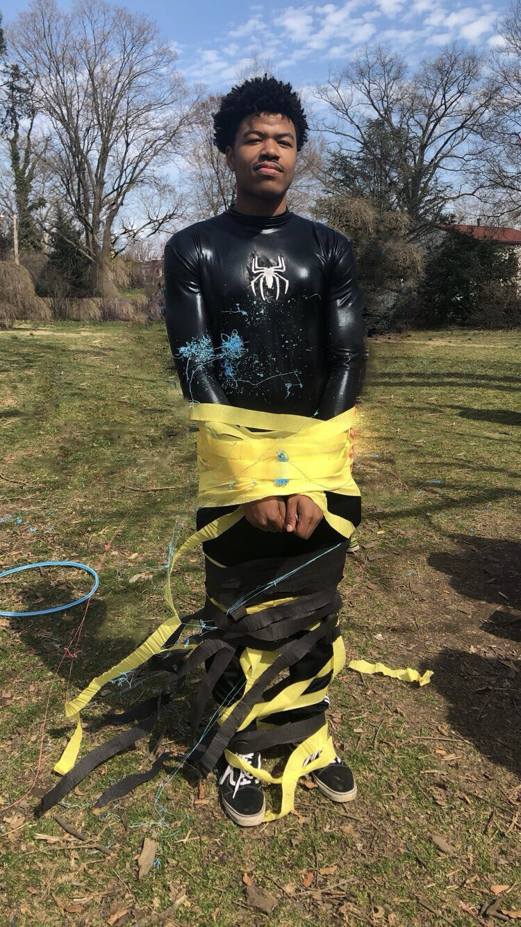 Man in Spiderman costume wound tight with crepe mache