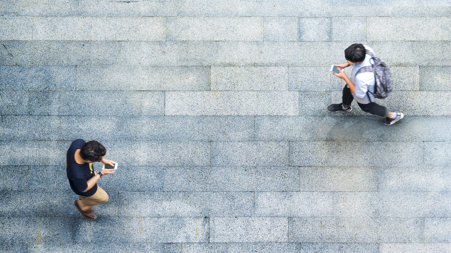 two people walking with phones
