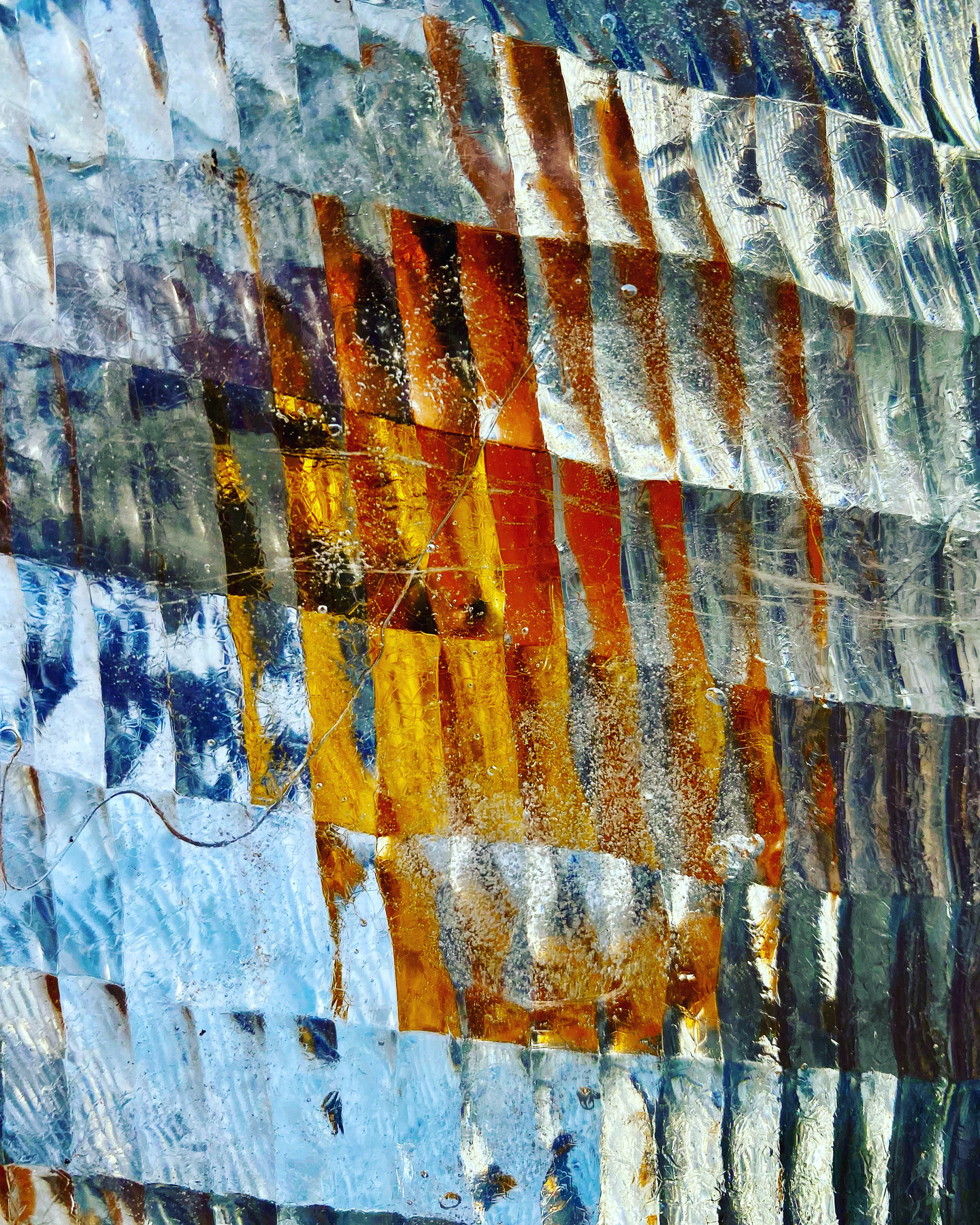 A blurry picture with many see-throughs rectangles. Behind them just colors of blue and orange and gray.