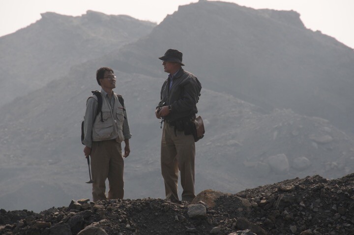 Two paleontologists with tools at an excavation site