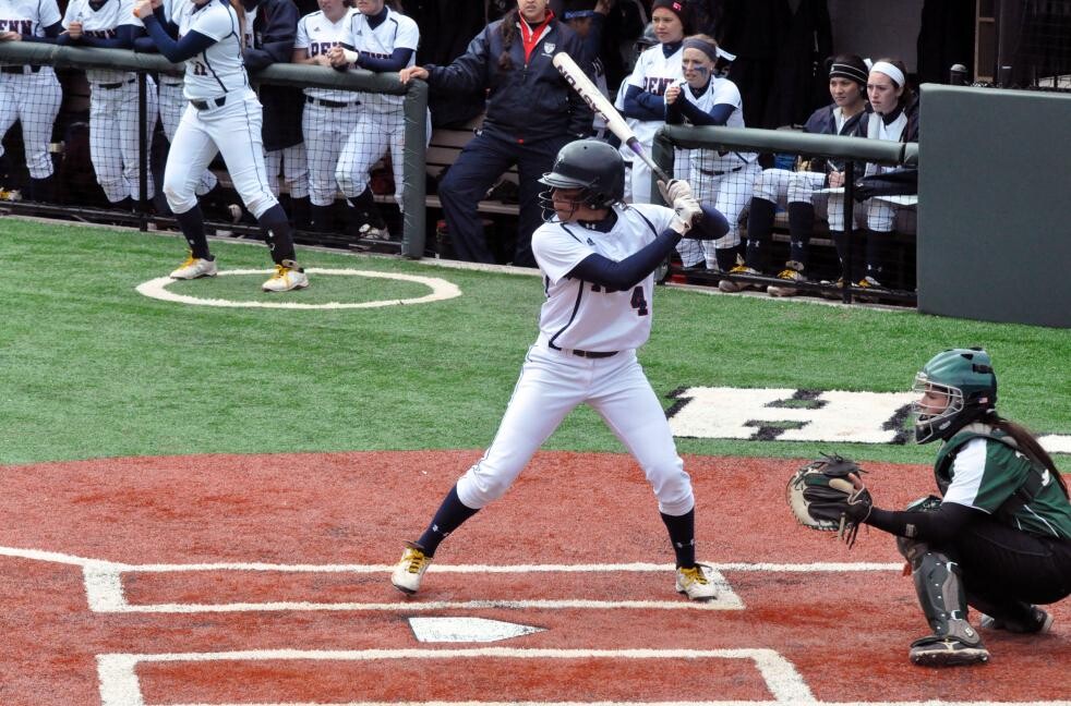 player standing at home plate in front of the catcher with baseball bat in ready position 