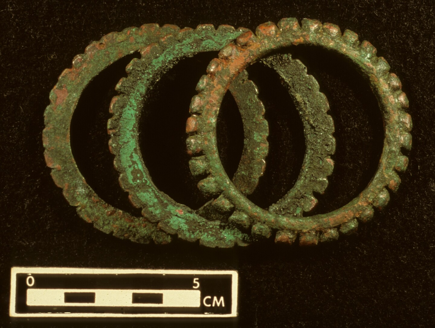 Three metal bracelets on a black background. in the foreground is a scale that runs from 0 to 5 cm. 