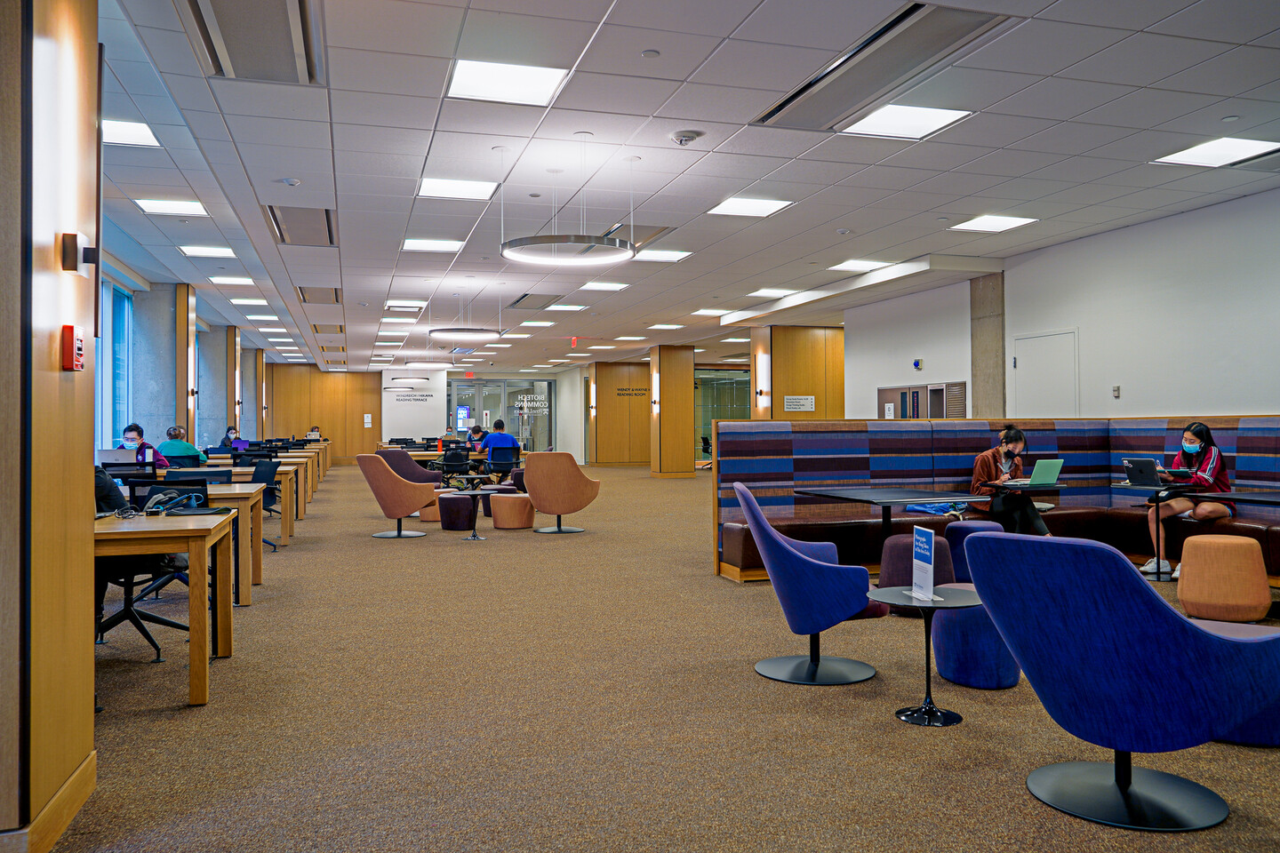 people seated at benches and tables in new libraries space
