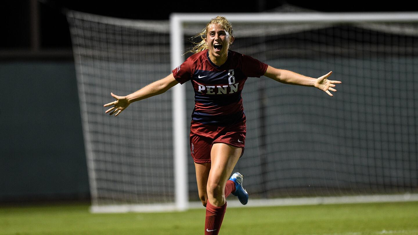 Senior Jackie Bruder celebrates with her arms stretched out wide.