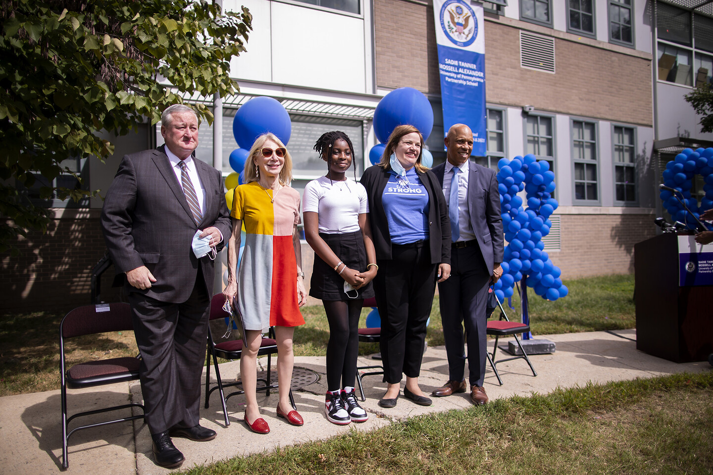 People pose for photo in front of blue balloons