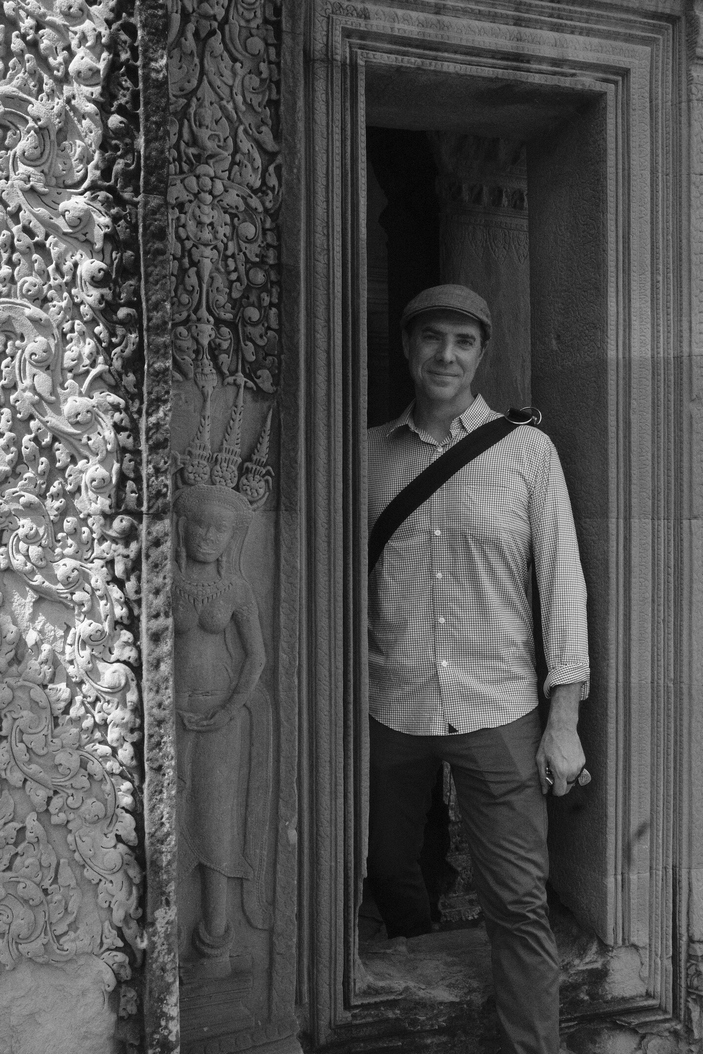 A man stands in an ornately carved doorway