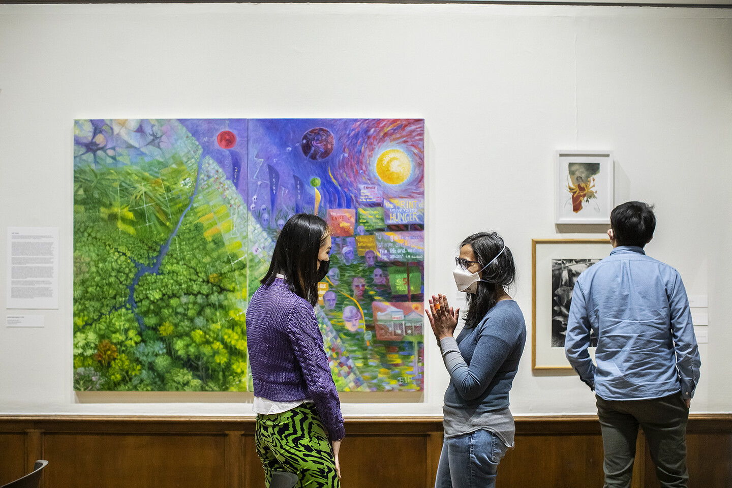two people talking in front of an artwork 