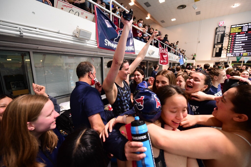 Thomas celebrates with her arms raised after a race.