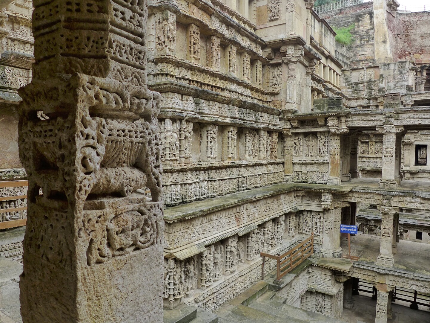 An open courtyard with a large stone building carved with characters. 
