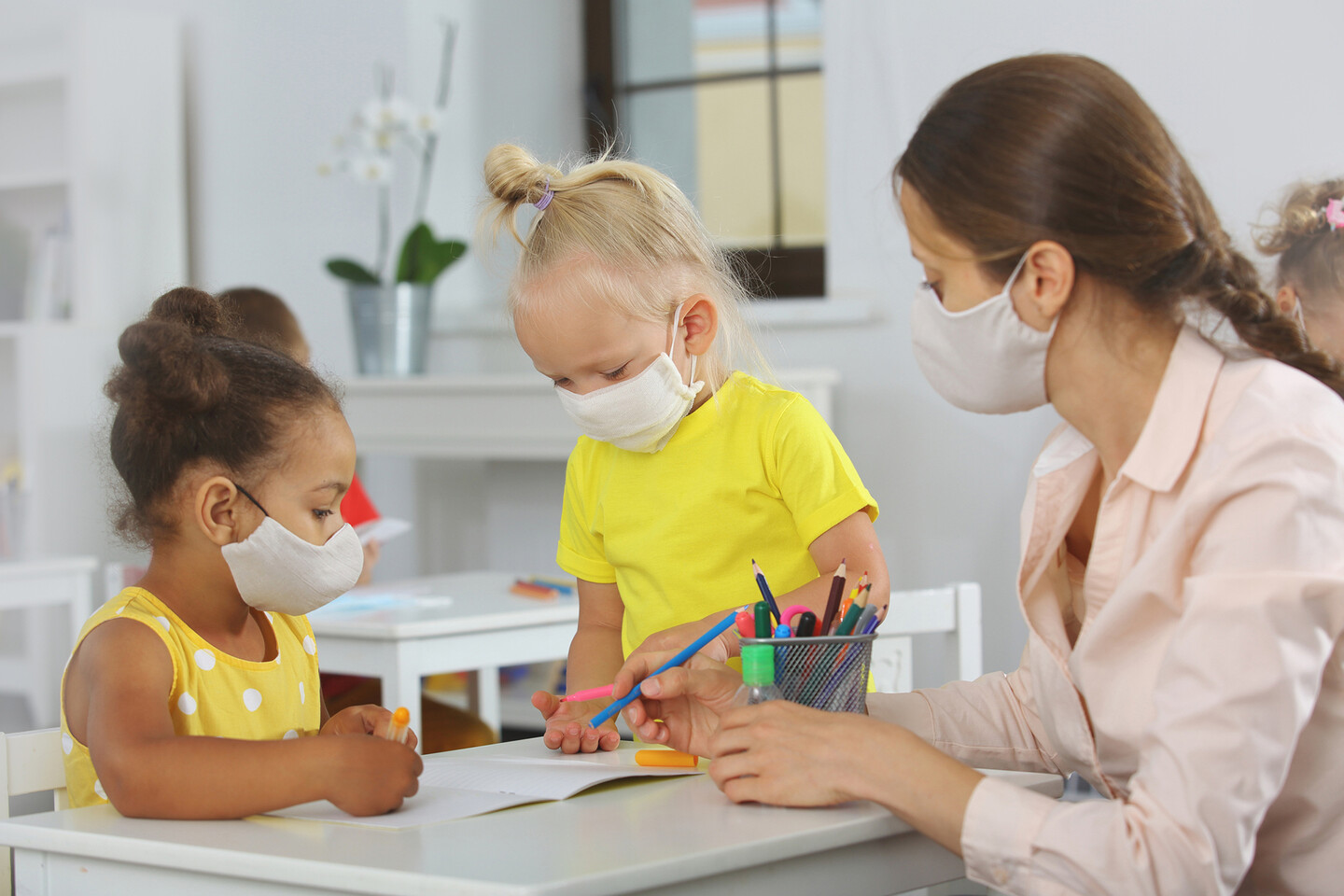 Preschool children work on art with a teacher