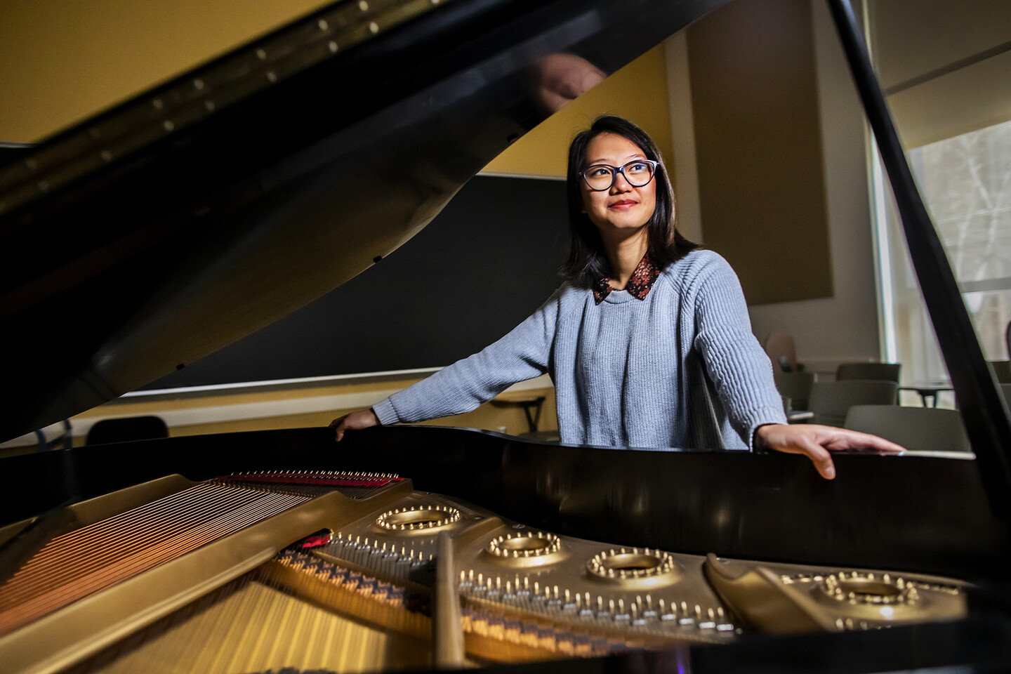 student standing with grand piano 