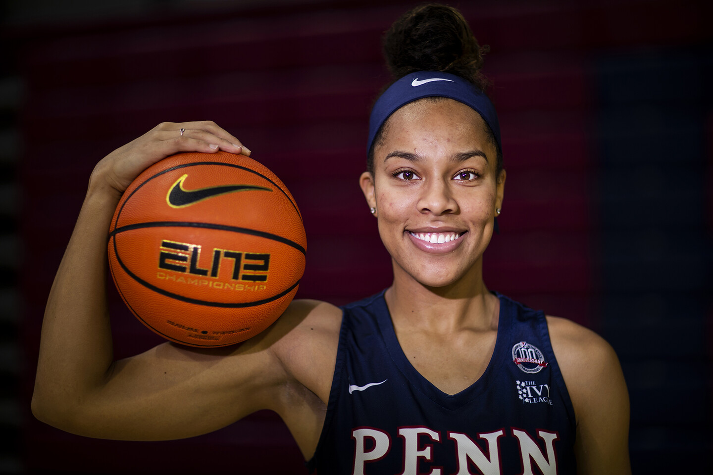 Suttle poses with a basketball resting on her shoulder.