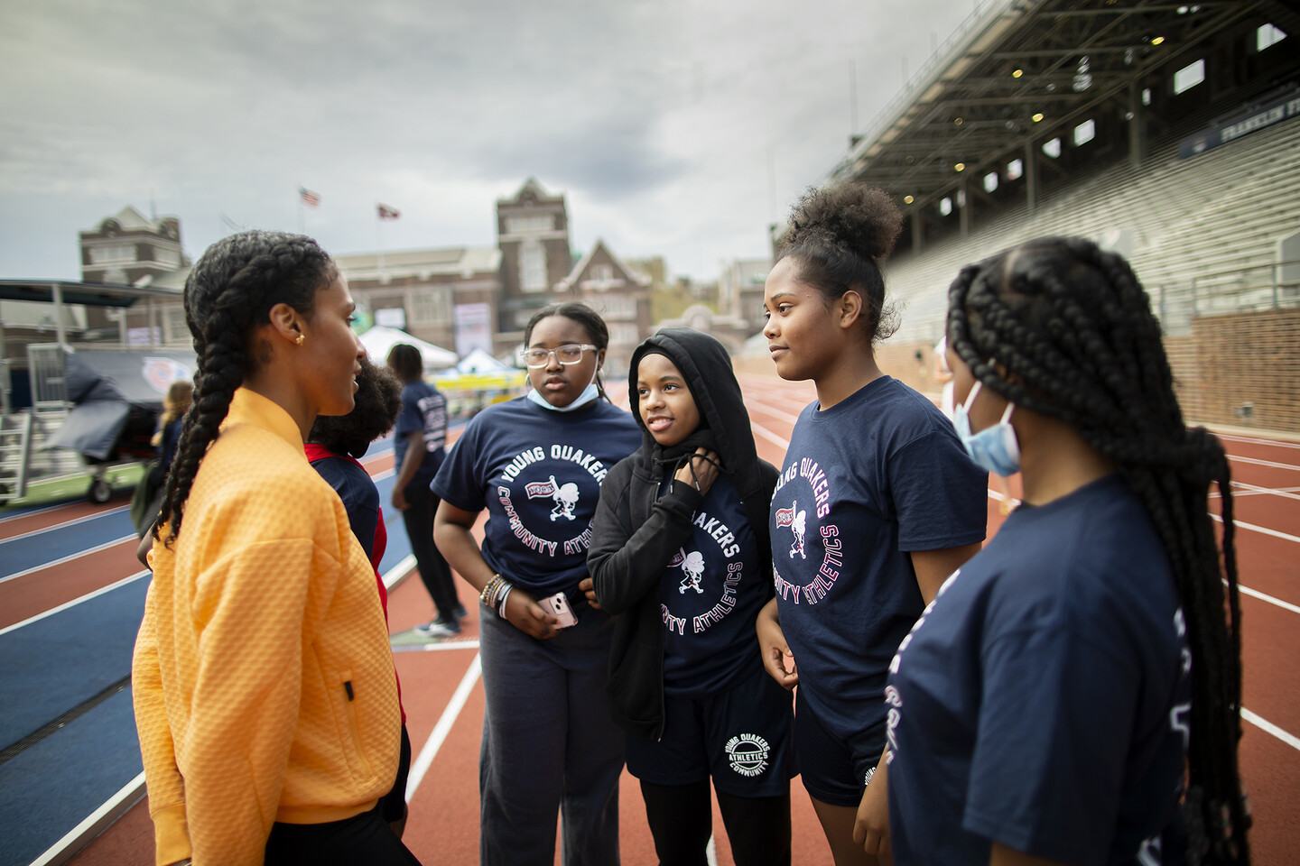 Ajee’ Wilson talking with 4 students from the Lea girls&nbsp;4x100 team at Franklin Field.