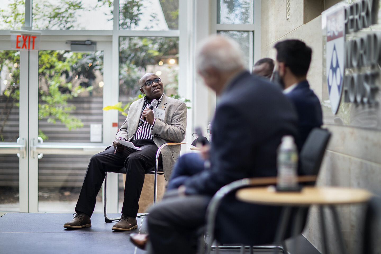 Wale Adebanwi holds a microphone while introducing a panel at Perry World House