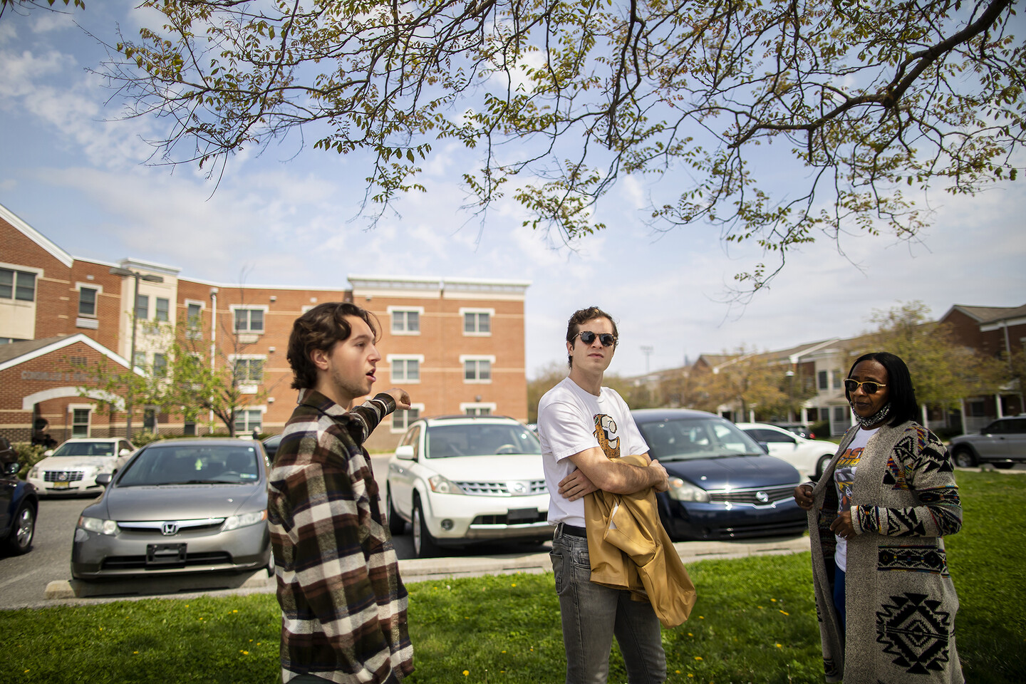 Eli Moraru, Alex Imbot, and Tammy Reeves stand at corner in front of a nursing home.