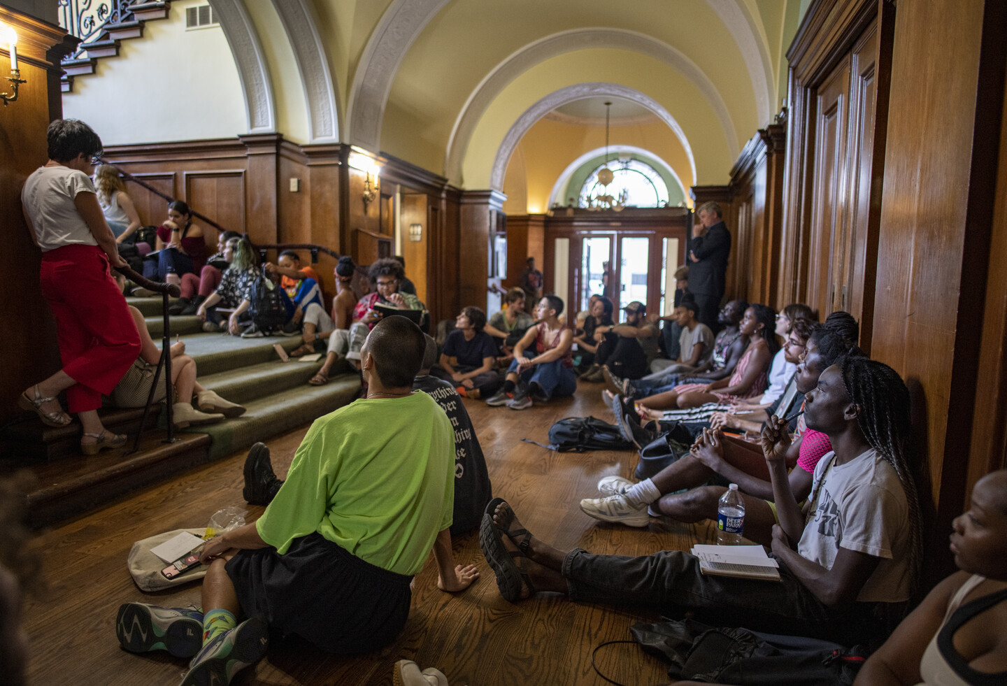 People congregated in foyer with notebooks and belongings