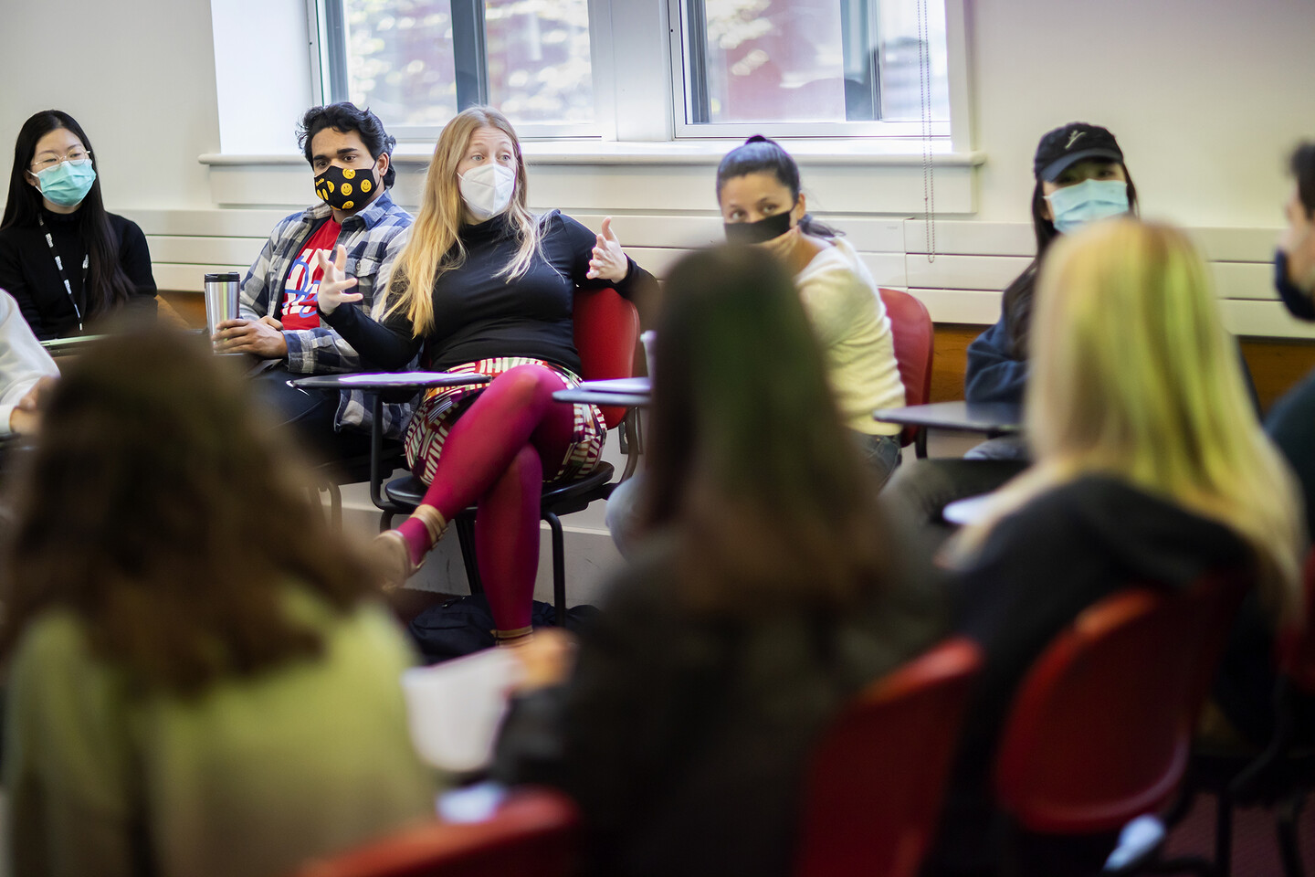 Whitney Trettien sitting among students in a classroom. 