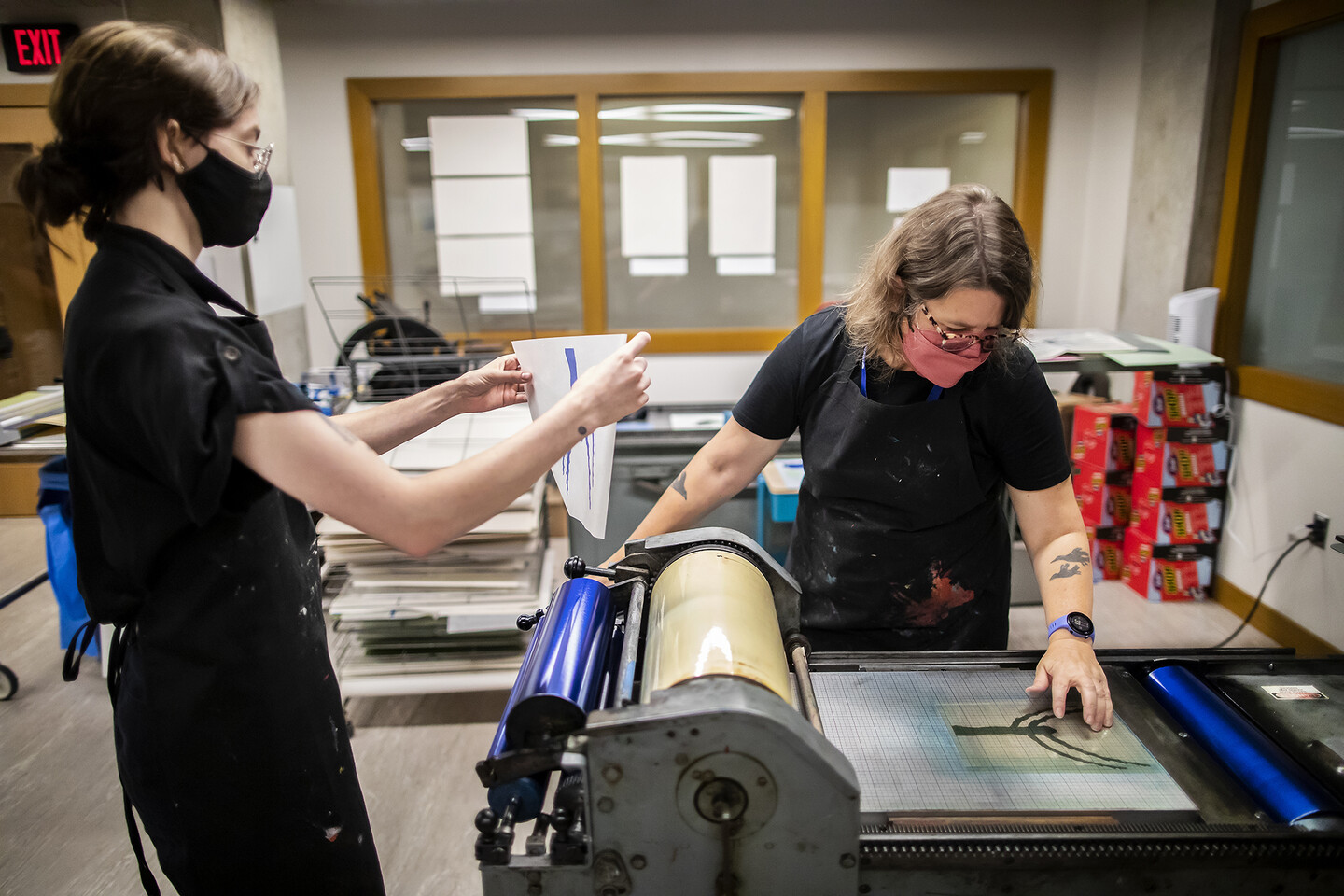 Katie Baldwin works at the press with intern Erica Honson