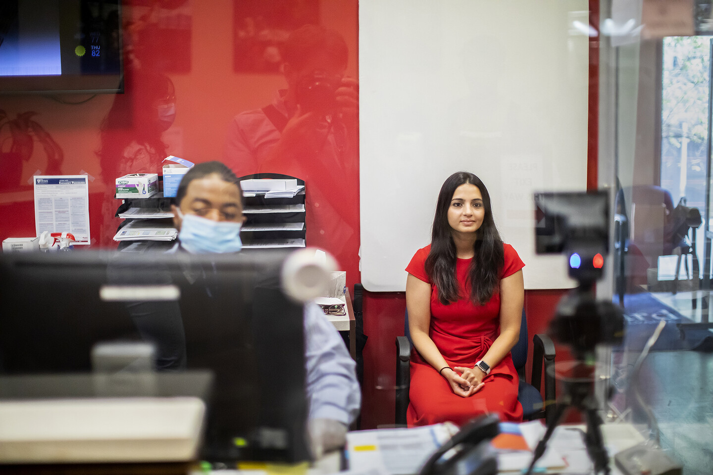 A person sits having their photo taken for a PennCard ID.