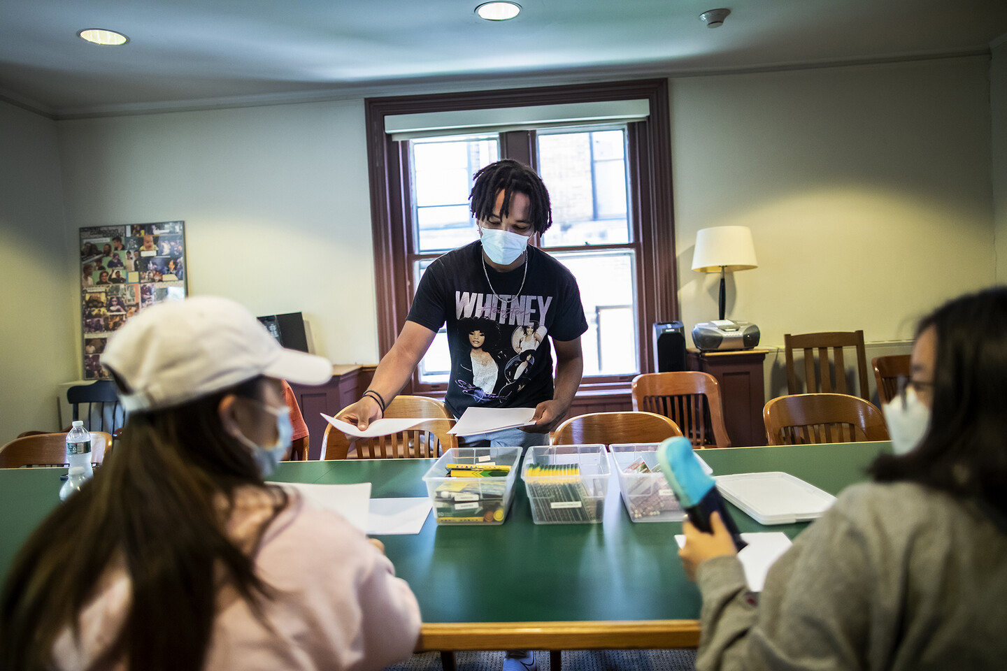Wes Matthews hands out papers during a class