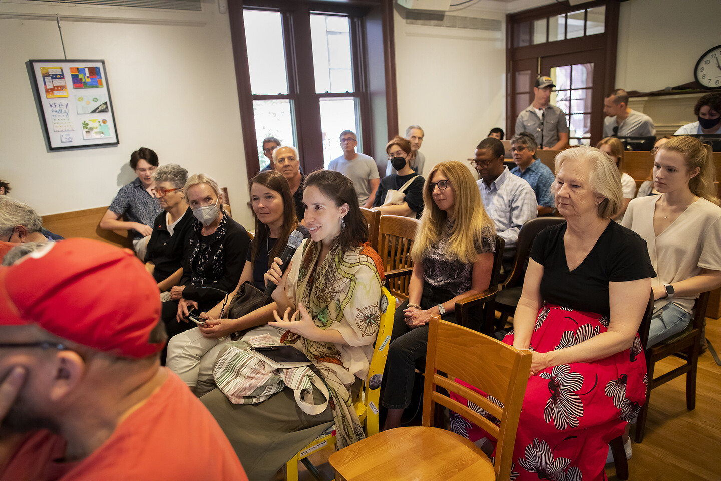 Irene Torra Mohedano speaking while sitting in chairs with others in the Kelly Writers House arts cafe