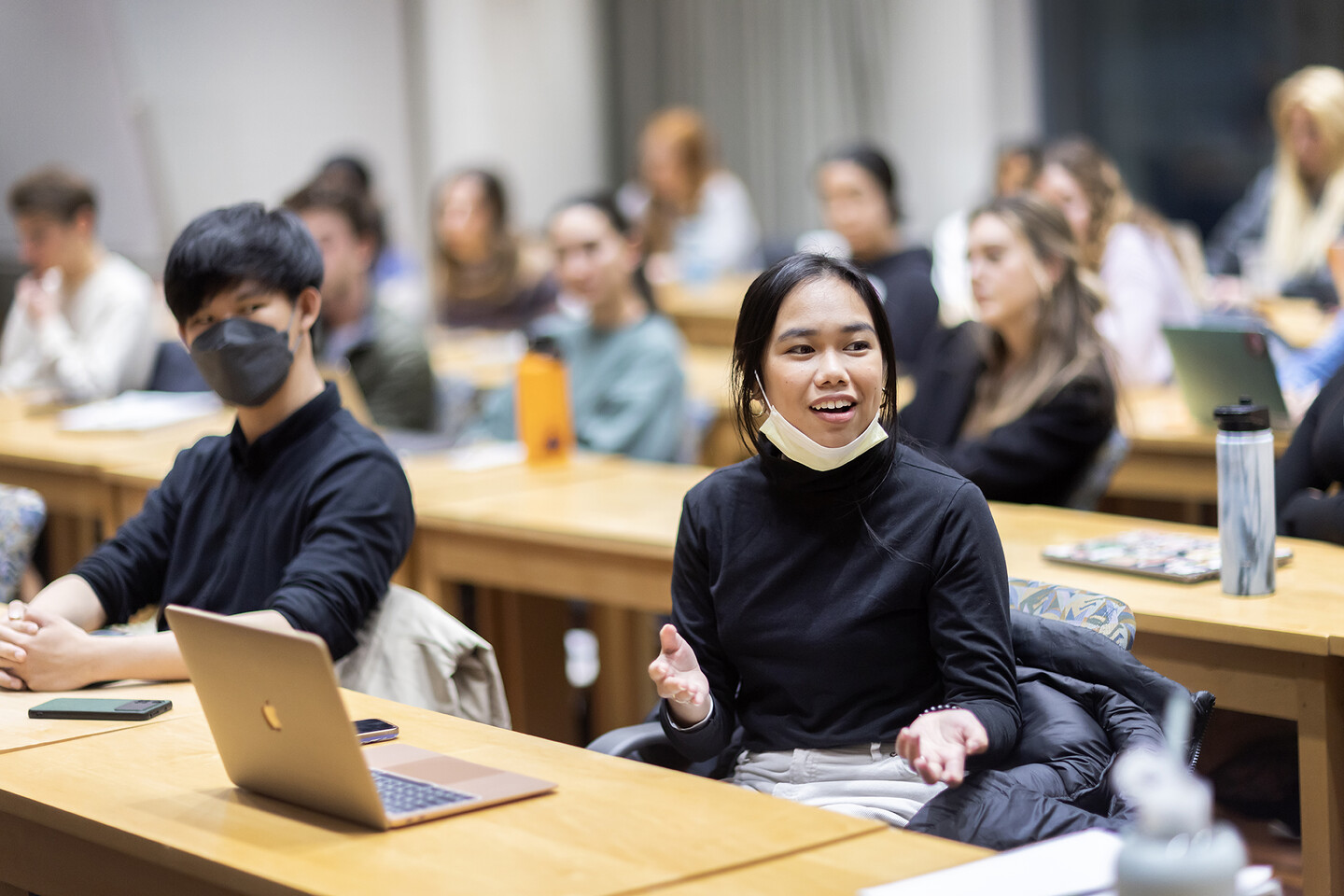 Students sit in rows, taking notes on laptops during class, and listening to Florell Leimena, who is speaking
