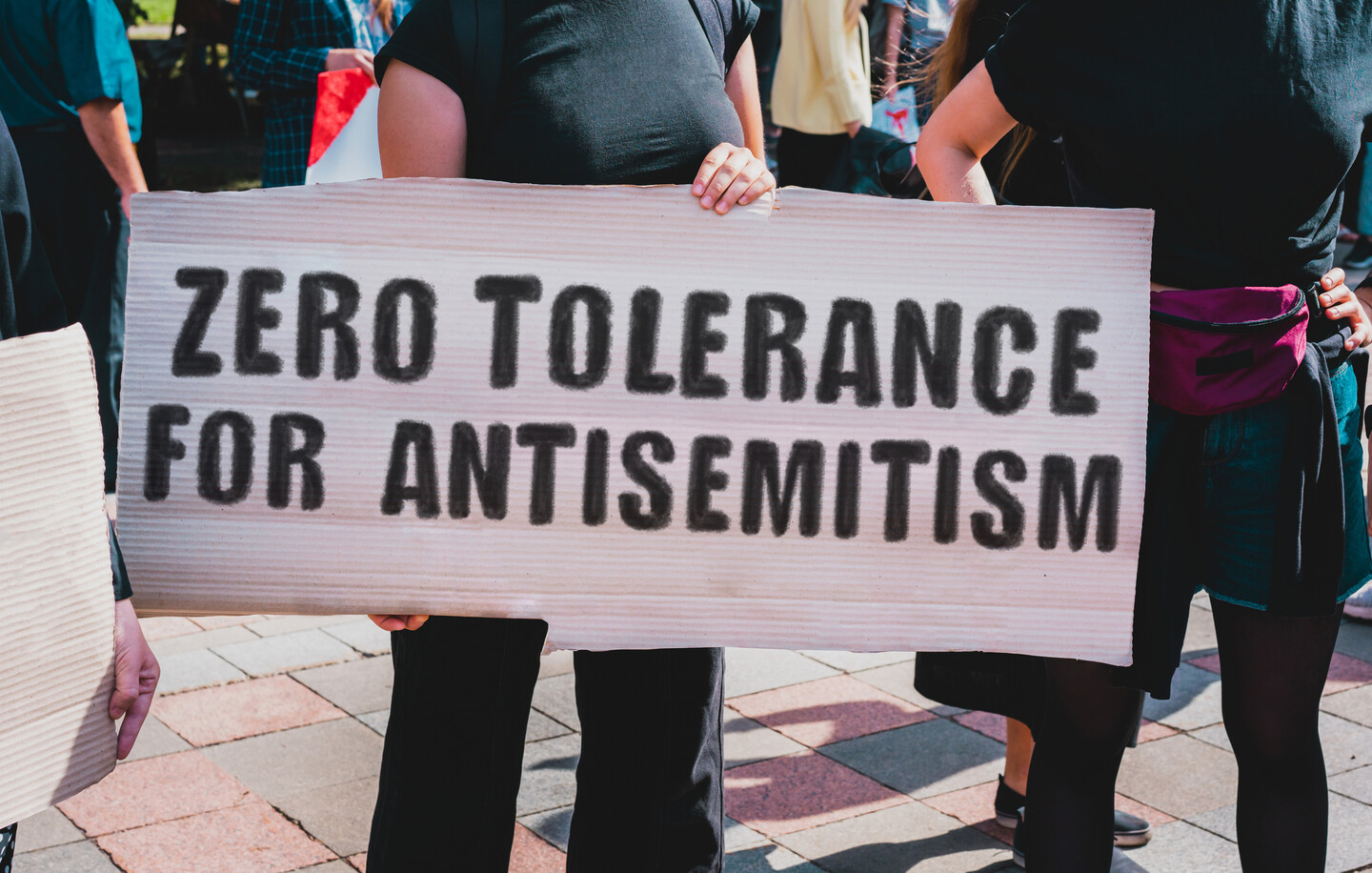 A person holds a sign reading "Zero Tolerance for Antisemitism."