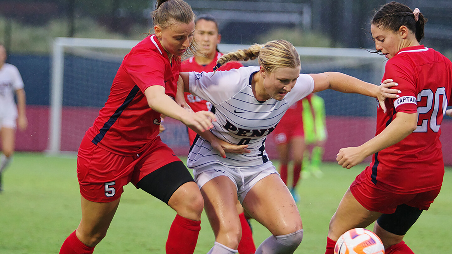 Lawton fights for the ball through two defender.