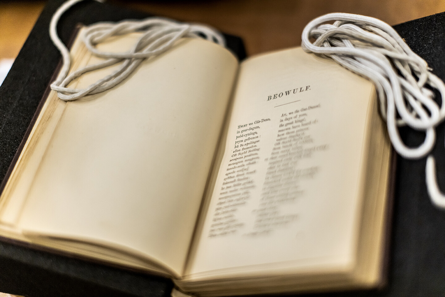A book open with the first page "Beowulf" 