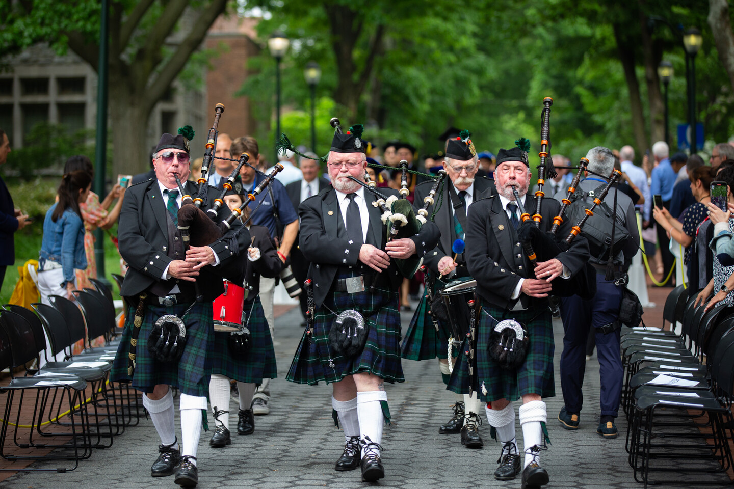 Three bagpipers proceeding on Locust Walk.