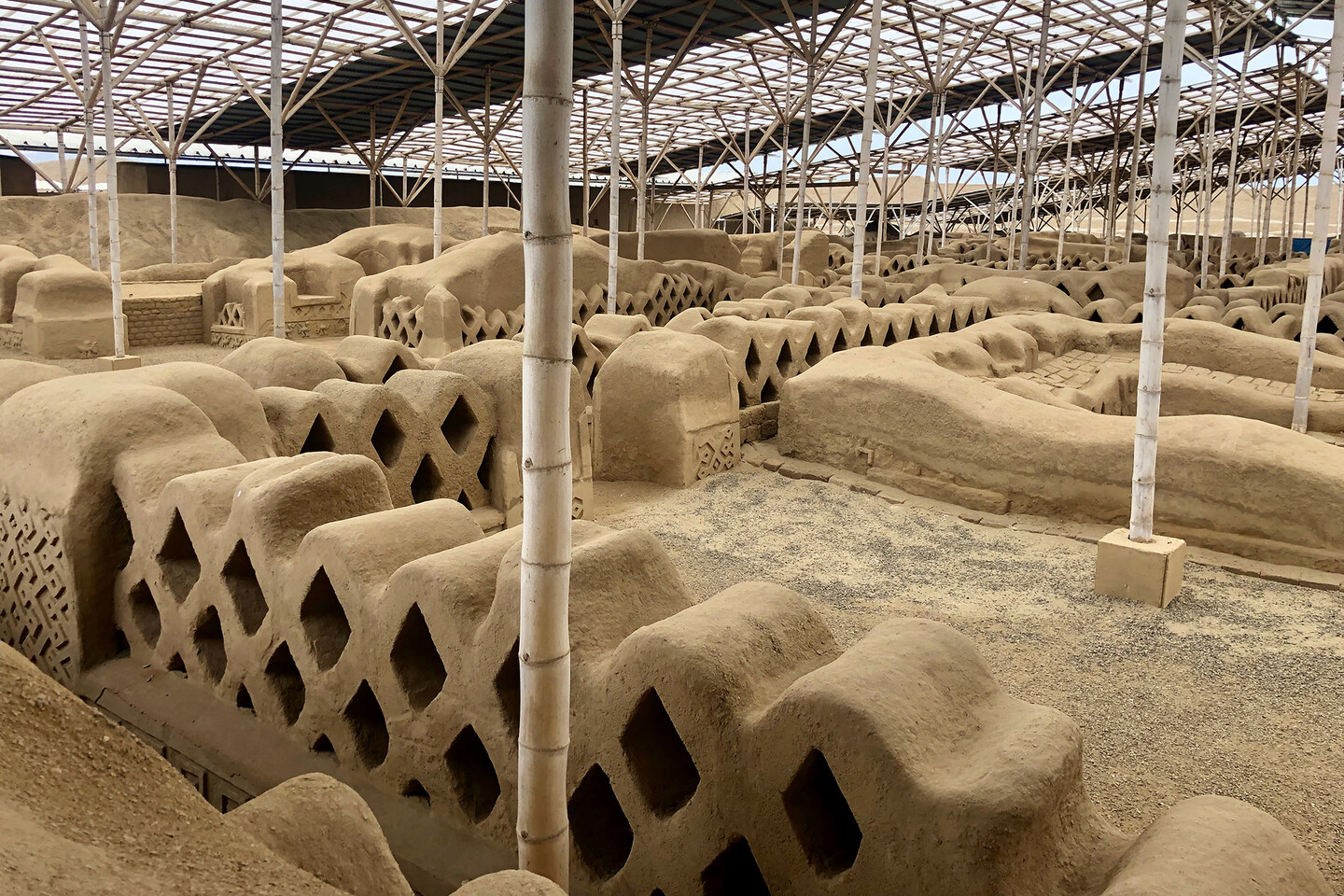 Archaeological site with diamond-shaped stones featuring scaffolding around them.