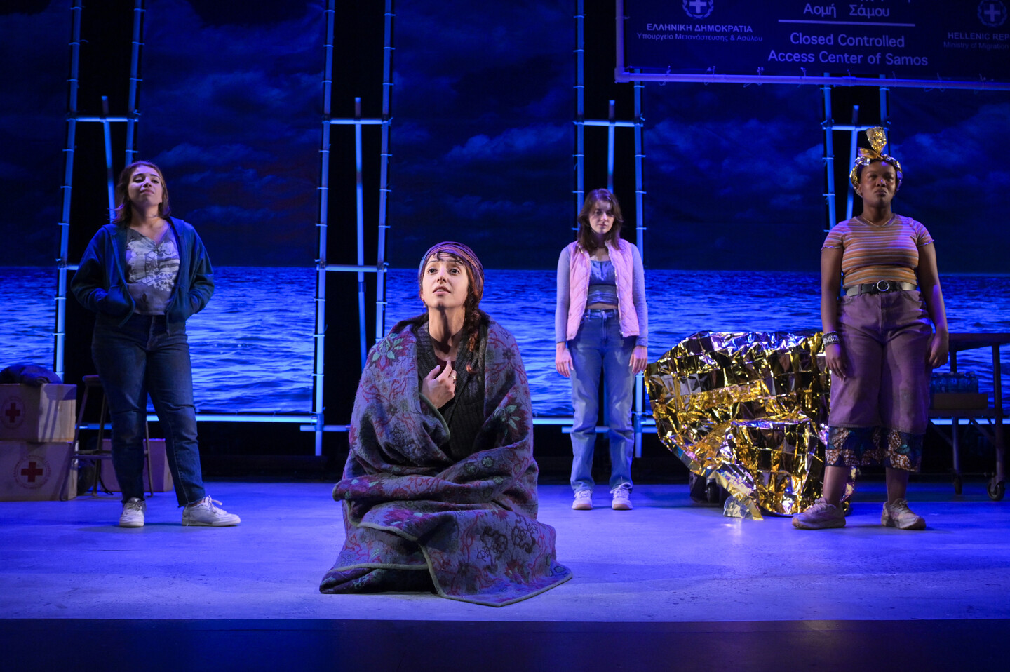 Four people on stage in Ancient Greek attire.