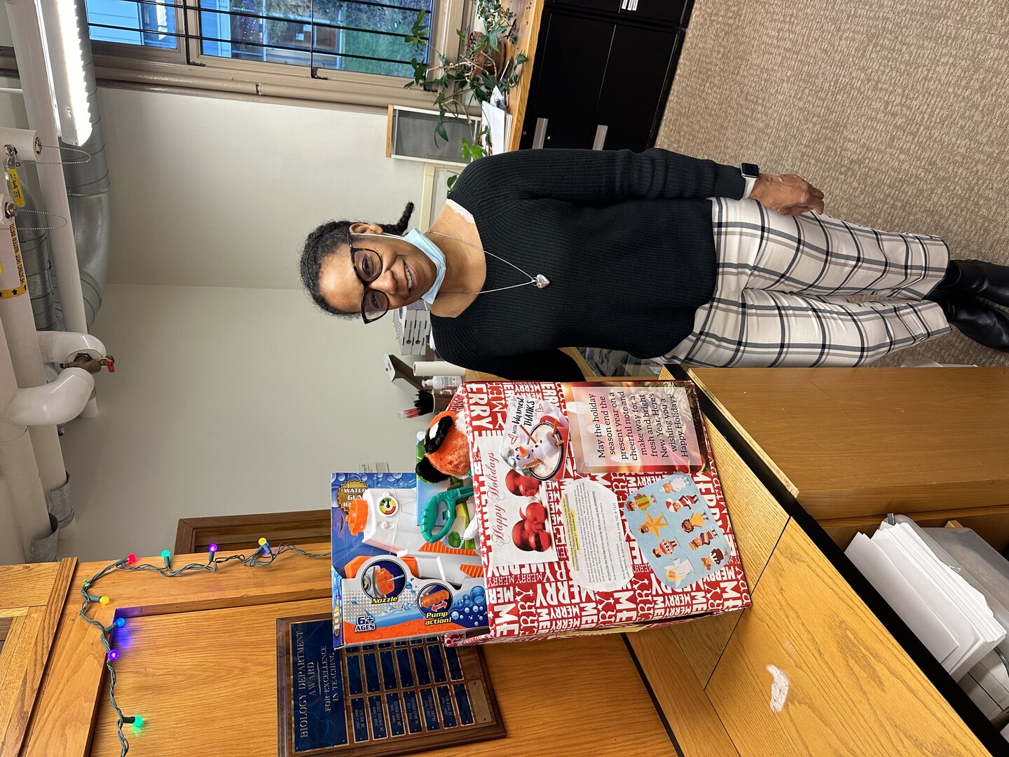 Leah Dennis stands next to a holiday package for a local family